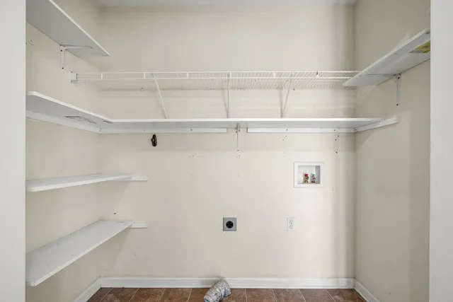 a front view of a house with a garden and tree