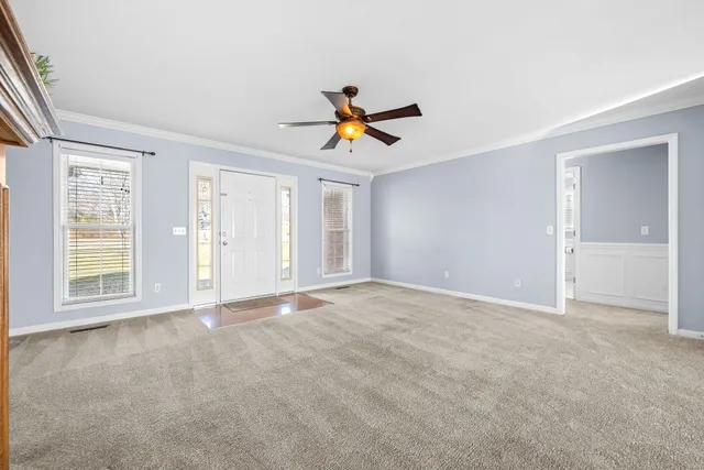 a view of an empty room with a fireplace and a window