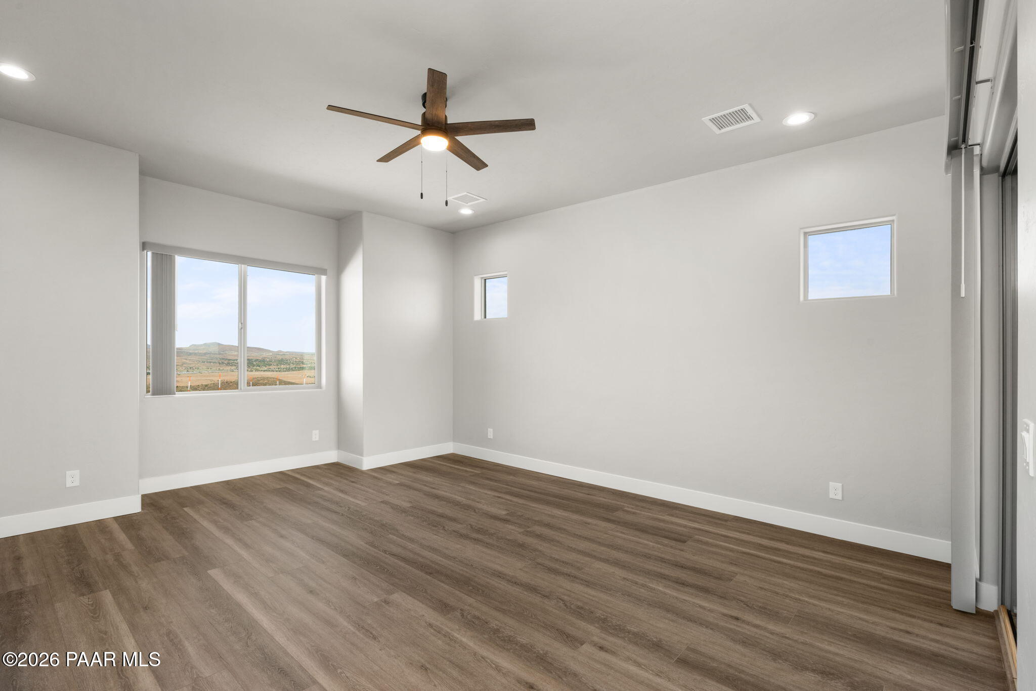 15690 East Orchard View Road Dewey, AZ 86327 - Photo 22 of 26 an empty room with wooden floor fan and windows