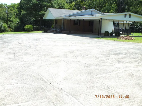 a front view of a house with a yard and car parked