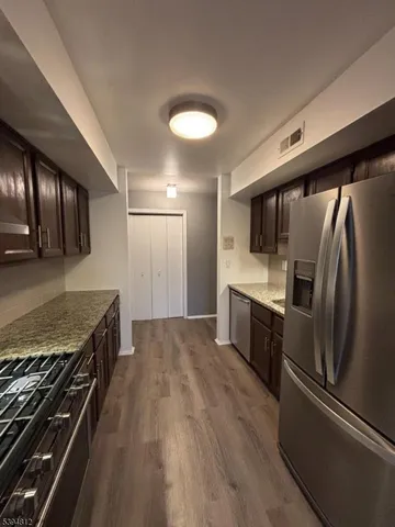 a kitchen with stainless steel appliances granite countertop a stove and a refrigerator