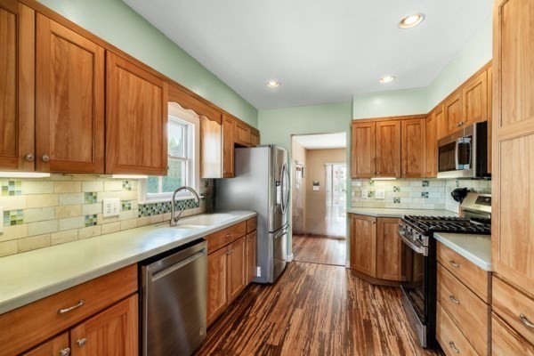 28 Gregg Street Beverly, MA 01915 - Photo 7 of 31 a kitchen with stainless steel appliances granite countertop wooden cabinets a refrigerator a sink a stove and dishwasher with wooden floor