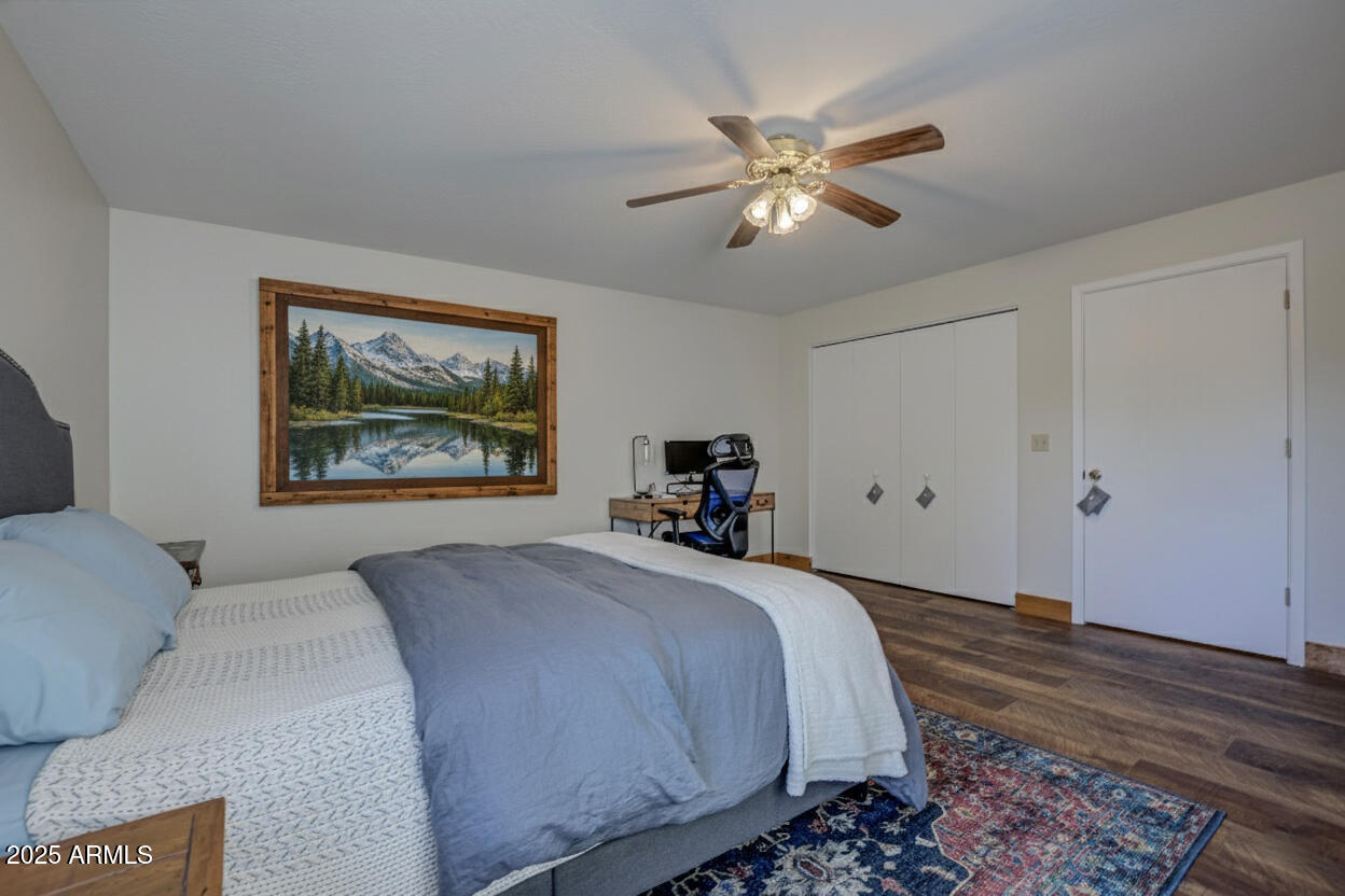 4823 Rim View Loop Pine, AZ 85544 - Photo 26 of 70 a bedroom with a bed and a chandelier