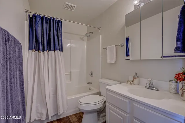 a view of a livingroom with wooden floor and a ceiling fan