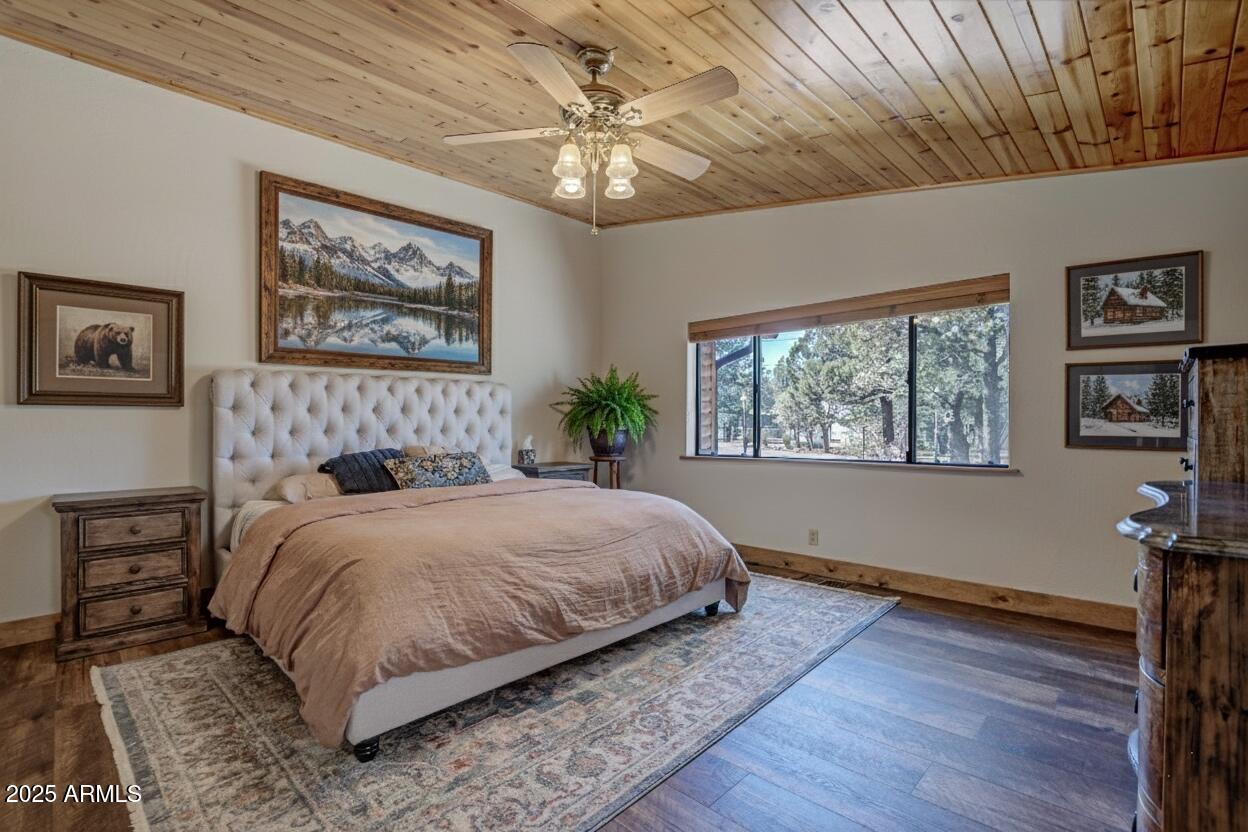 4823 Rim View Loop Pine, AZ 85544 - Photo 29 of 70 a bedroom with a large bed a chandelier and a window