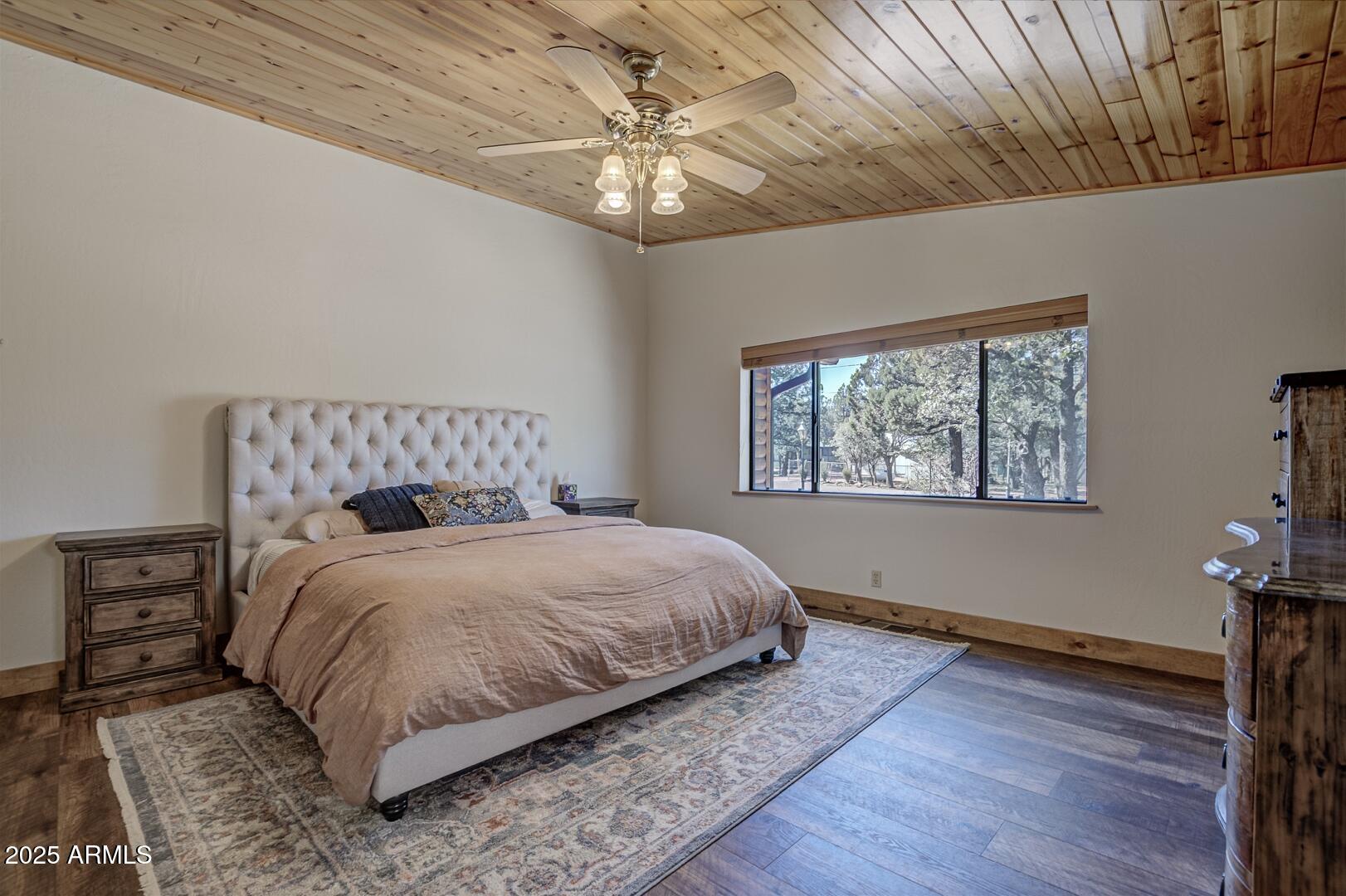 4823 Rim View Loop Pine, AZ 85544 - Photo 30 of 70 a bedroom with a large bed chandelier and a window