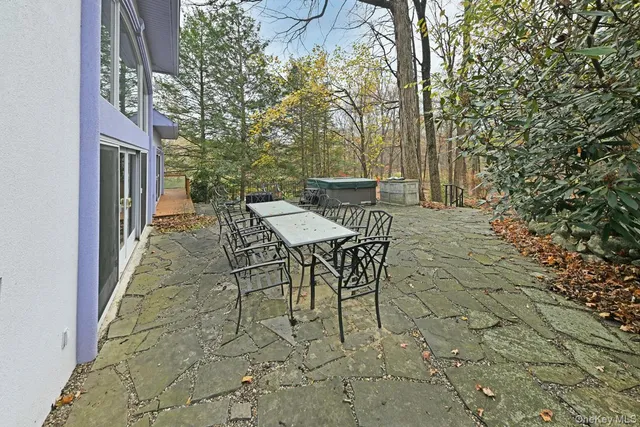 a view of a patio with table and chairs and floor to ceiling window
