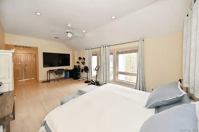 a bedroom with a bed flat screen tv and a window