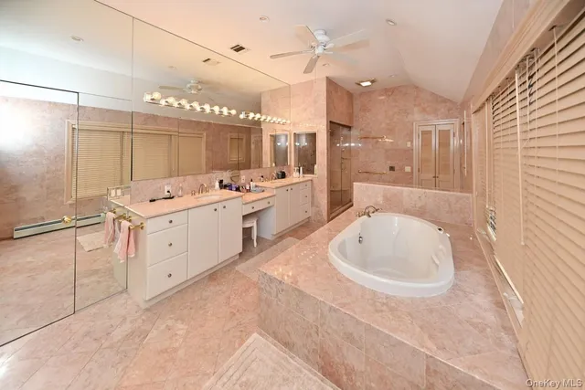 a large white bathroom with a large tub sink vanity and granite