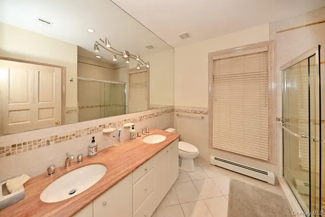 a bathroom with a double vanity sink mirror and toilet