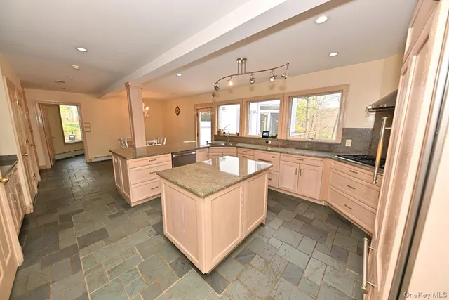a large kitchen with stainless steel appliances granite countertop a sink and cabinets