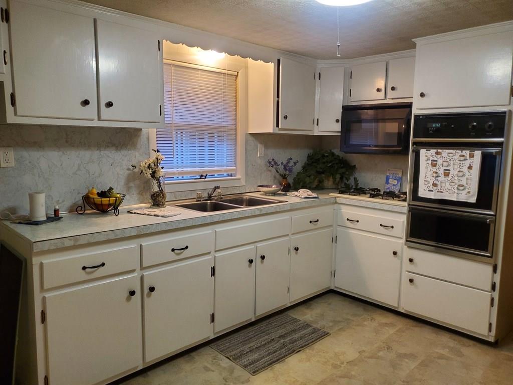 808 Patriots Road Templeton, MA 01468 - Photo 2 of 22 a kitchen with granite countertop white cabinets and white appliances