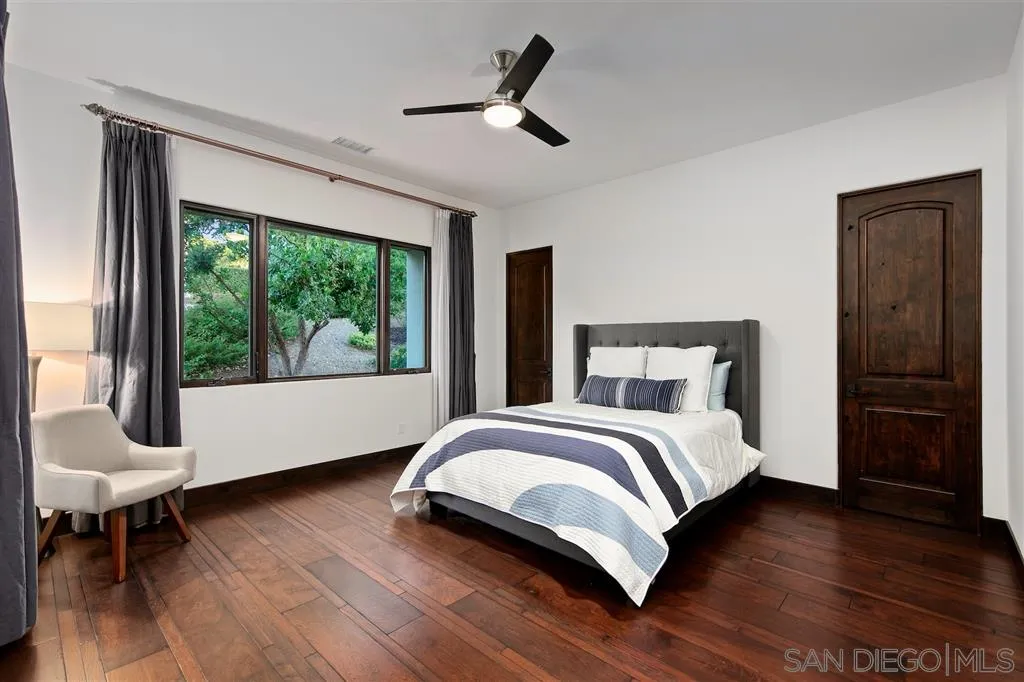 6806 St Andrews Road Rancho Santa Fe, CA 92067 - Photo 20 of 25 a bedroom with a large bed and a large window