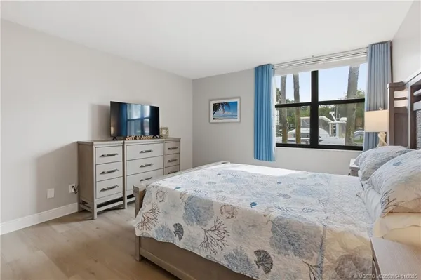 a bedroom with a bed and a flat tv screen on dresser