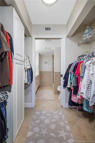 a view of walk in closet with clothes and shoes