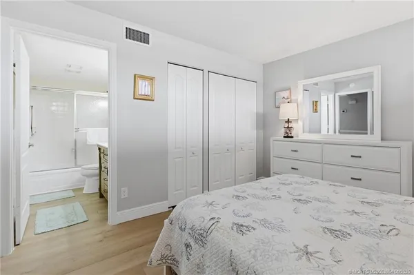 a bedroom with a large bed and a mirror on dresser