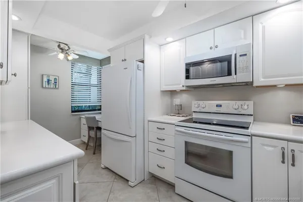 a kitchen with white cabinets stainless steel appliances and sink