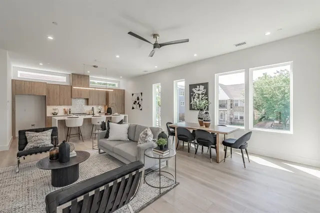 a living room with furniture kitchen view and a large window