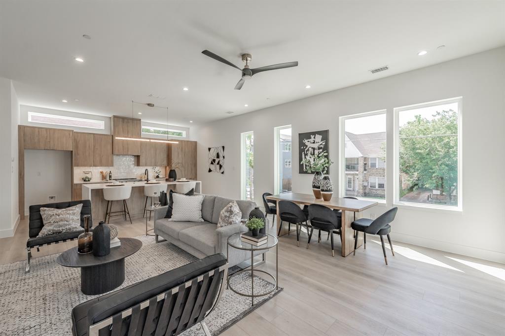 a living room with furniture kitchen view and a large window