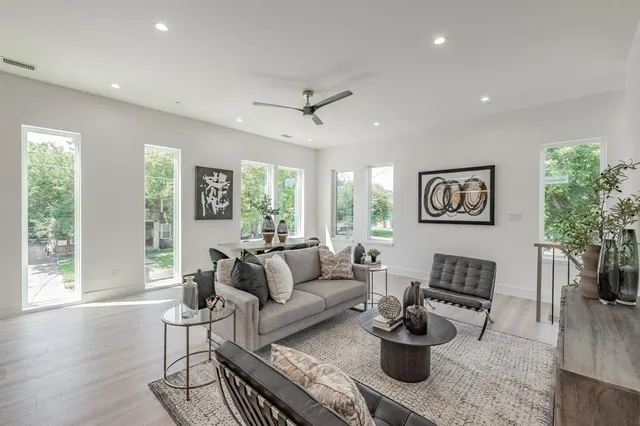 a living room with furniture a flat screen tv and a large window