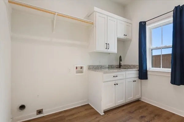 a room with granite countertop white cabinets and sink