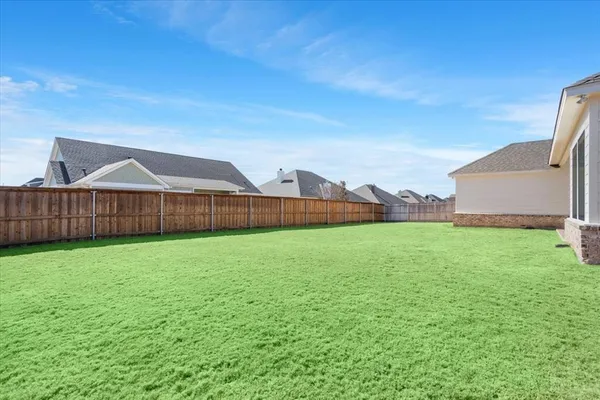 a view of a house with backyard and a garden