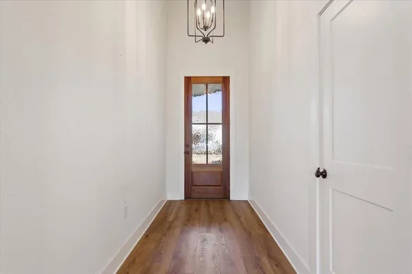 a view of a hallway with wooden floor and closet