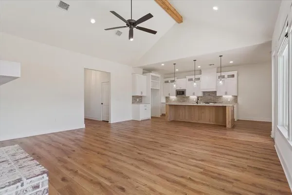 a view of a kitchen with wooden floor and a sink