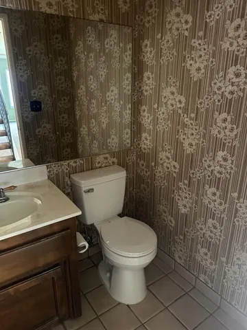 a bathroom with a granite countertop sink a toilet a mirror and bathtub