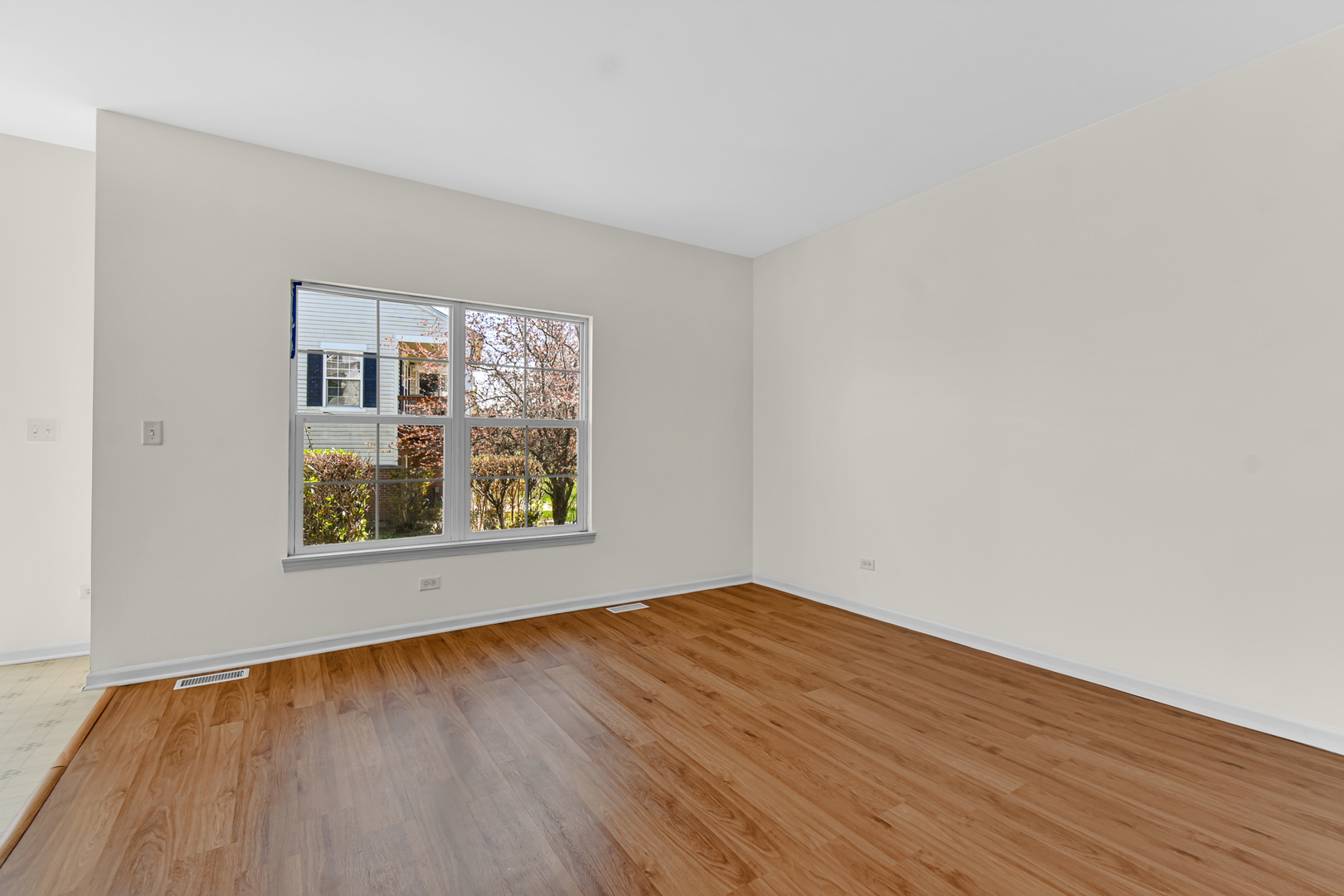 16743 Winding Creek Road Plainfield, IL 60586 - Photo 11 of 25 an empty room with wooden floor and window