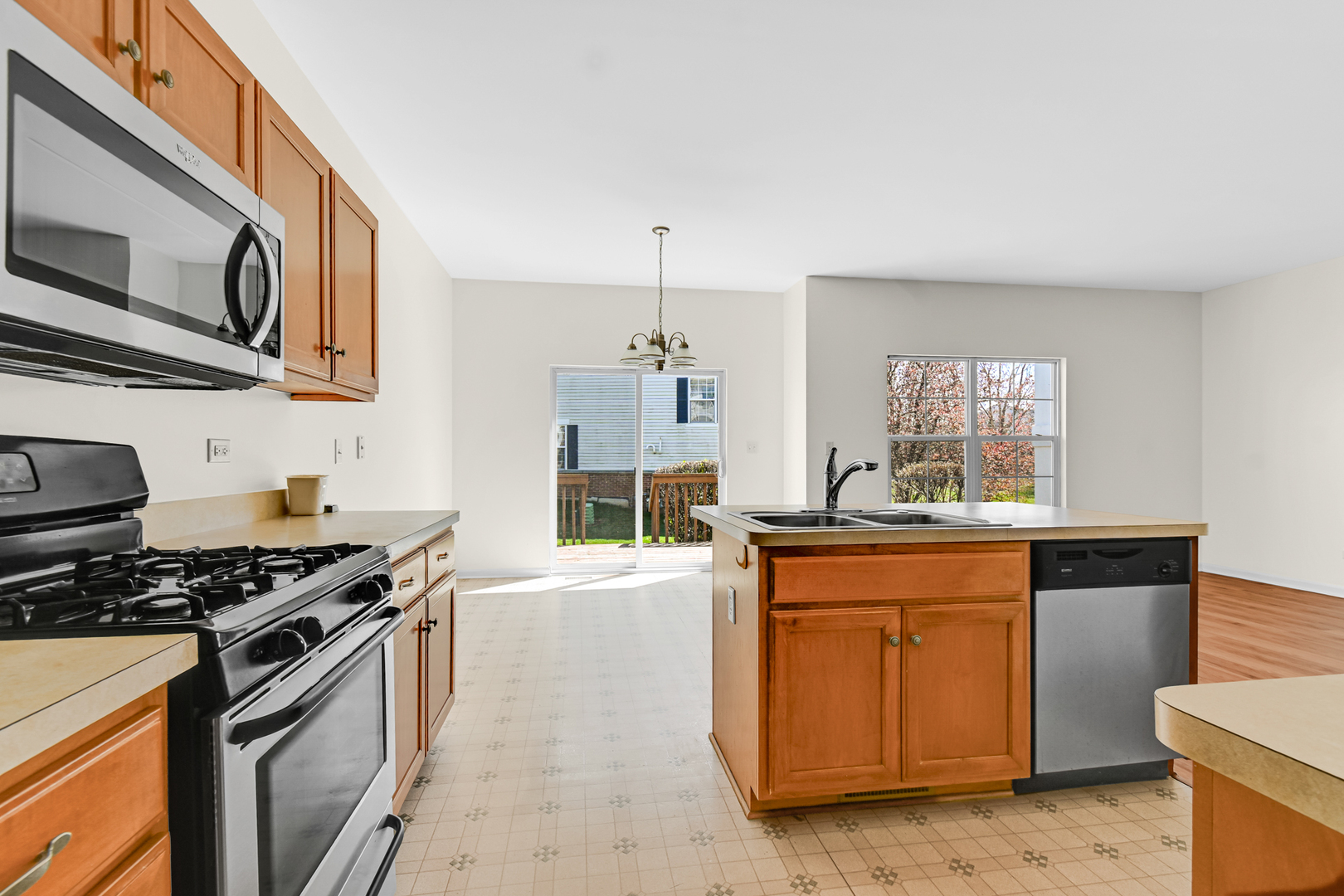 16743 Winding Creek Road Plainfield, IL 60586 - Photo 6 of 25 a kitchen with stainless steel appliances granite countertop a stove a sink and a microwave