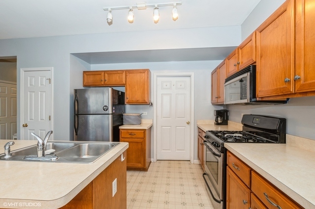 16743 Winding Creek Road Plainfield, IL 60586 - Photo 7 of 25 a kitchen with stainless steel appliances granite countertop a sink a stove and a refrigerator