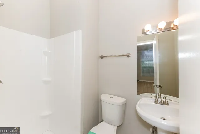 a bathroom with a toilet a sink and mirror