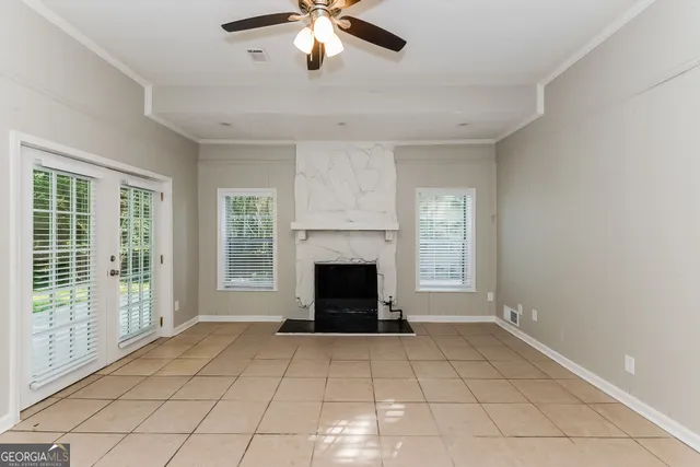 an empty room with windows and fireplace