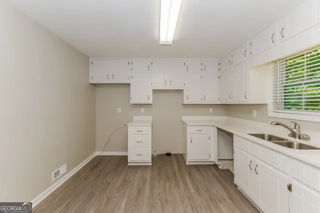 a kitchen with cabinets wooden floor and a sink