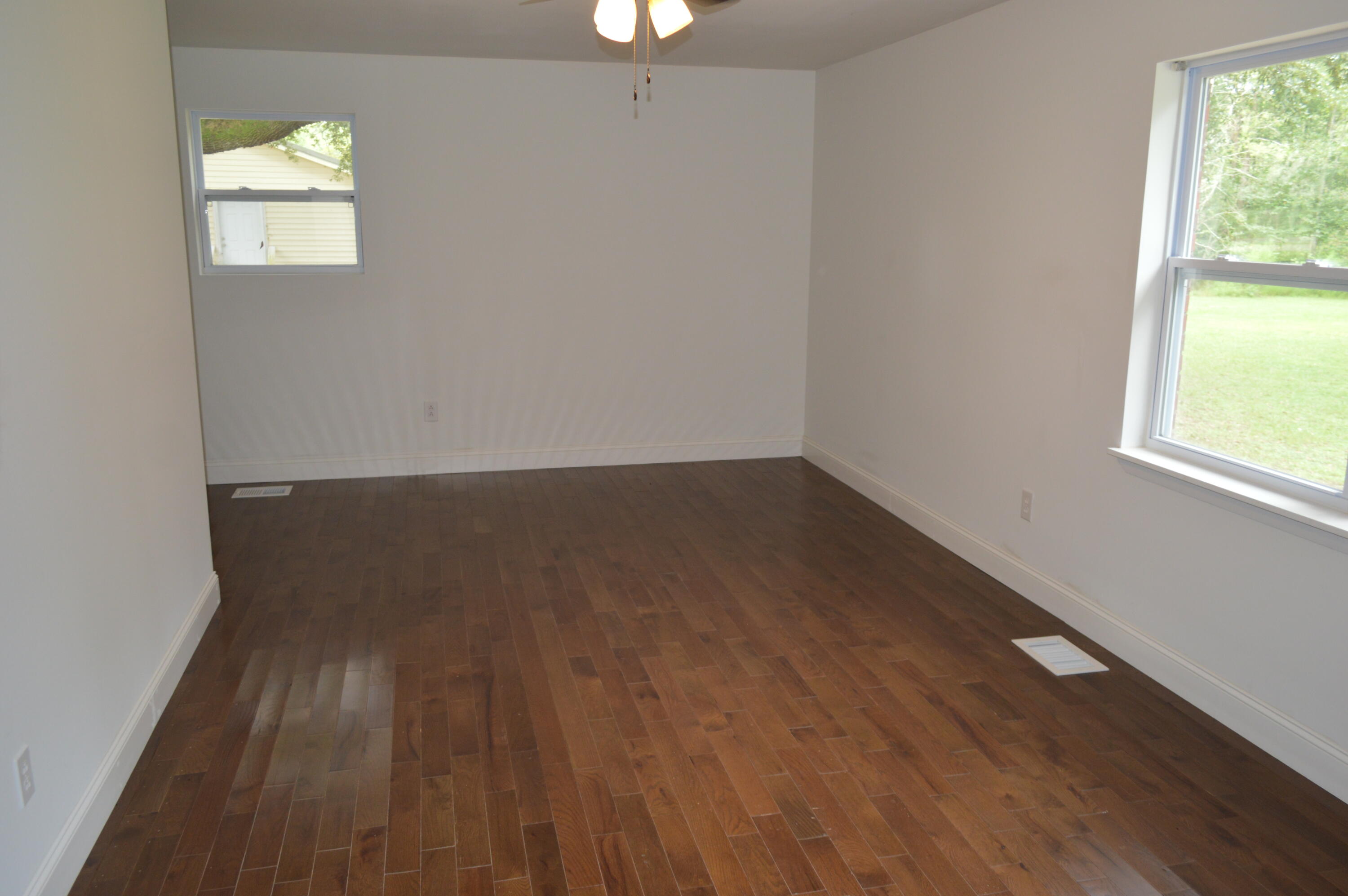 7582 Goat Hill Road See Remarks, AL 36477 - Photo 19 of 43 an empty room with wooden floor cabinet and windows
