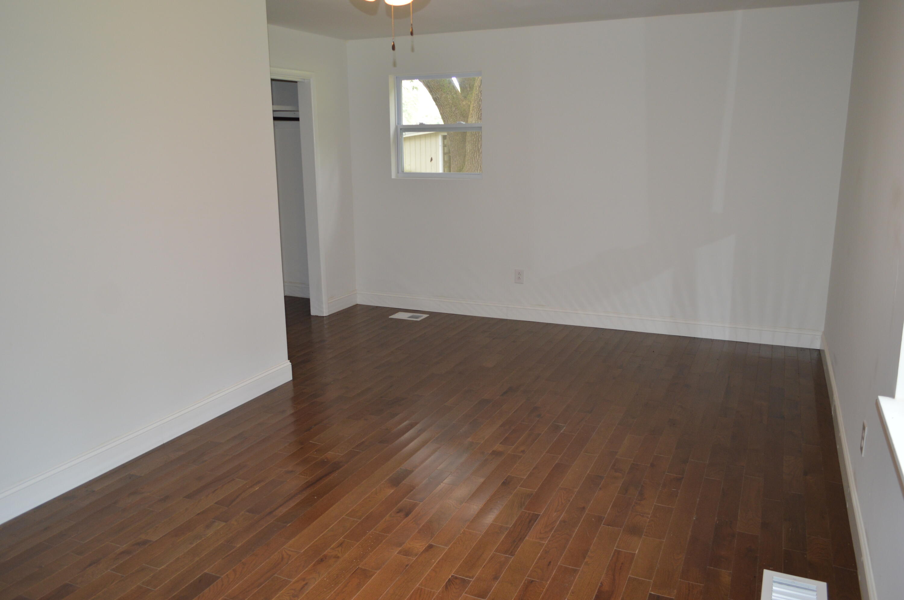 7582 Goat Hill Road See Remarks, AL 36477 - Photo 20 of 43 an empty room with wooden floor and windows