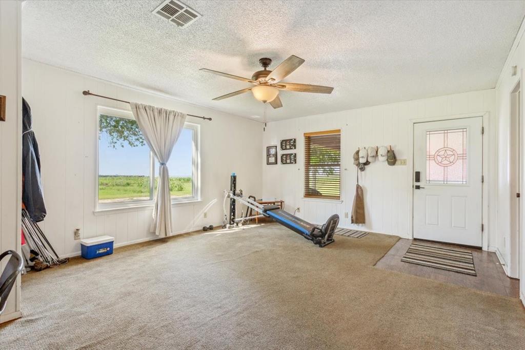 221 County Road 157 Riesel, TX 76682 - Photo 22 of 30 Exercise area featuring carpet flooring, ceiling fan, and a textured ceiling