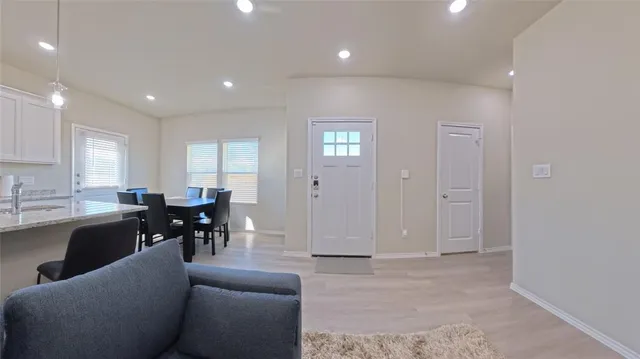 a living room with stainless steel appliances kitchen island granite countertop furniture wooden floor and a view of kitchen