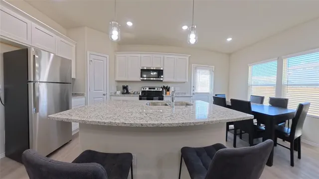 a kitchen with stainless steel appliances granite countertop a refrigerator stove and microwave
