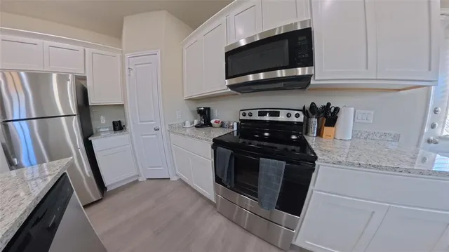 a kitchen with a table chairs sink and cabinets