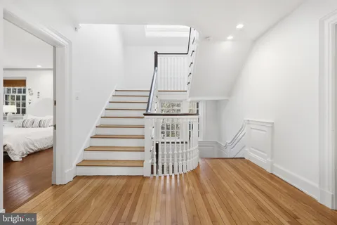 a bedroom with a bed and a table with wooden floor