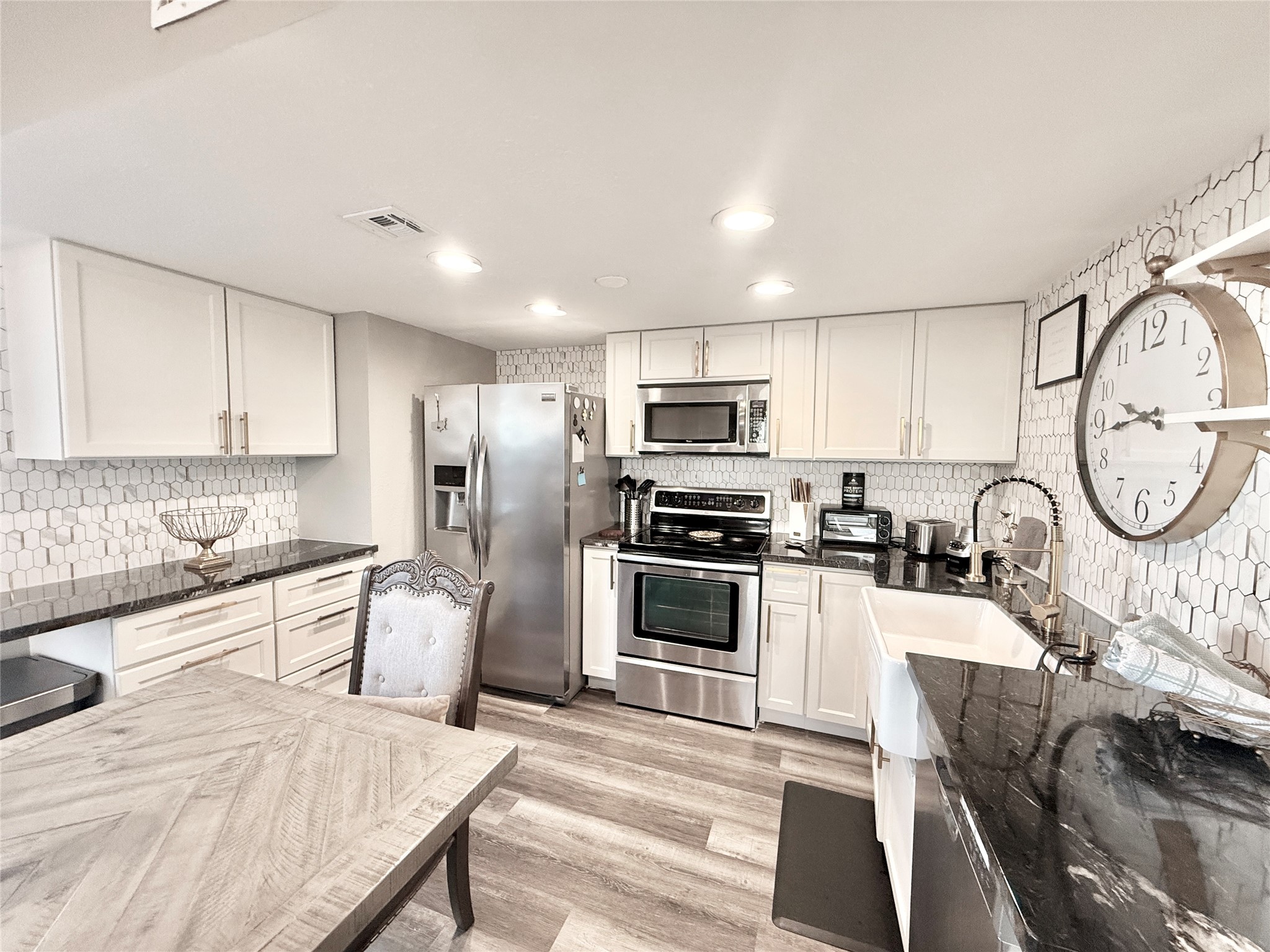 2016 Main Street, Unit 1022 Houston, TX 77002 - Photo 8 of 48 a kitchen with stainless steel appliances granite countertop a stove top oven a sink dishwasher a dining table and chairs with wooden floor