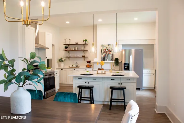 a dining room with furniture potted plants and wooden floor