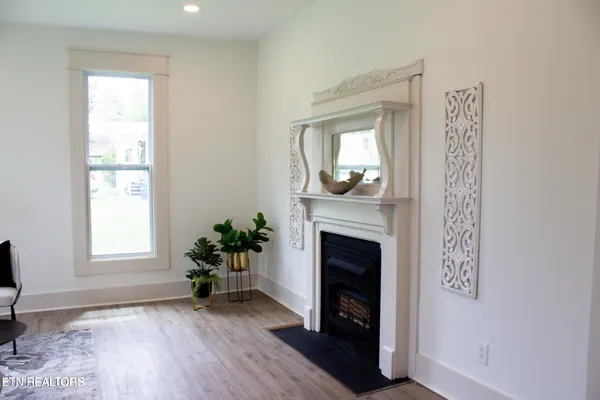 a view of an empty room with window and wooden floor