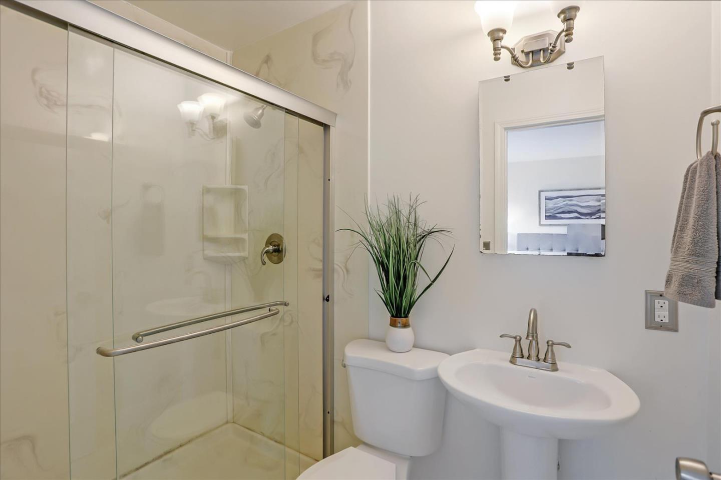 202 Greentree Way Milpitas, CA 95035 - Photo 23 of 28 a bathroom with a sink a mirror a potted plant a toilet and shower