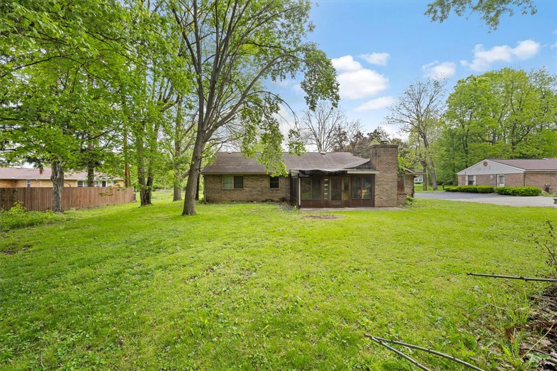 7225 Garber Road Clayton, OH 45415 - Photo 32 of 33 This spacious backyard offers ample green space and a charming brick home with a cozy screened porch.