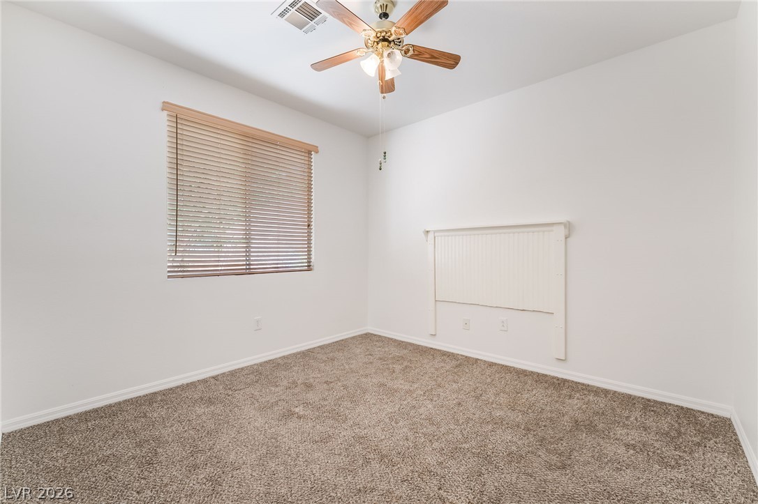 5389 Progresso Street Las Vegas, NV 89135 - Photo 23 of 41 Well-lit room with plush carpeting and a versatile ceiling fan for comfort.