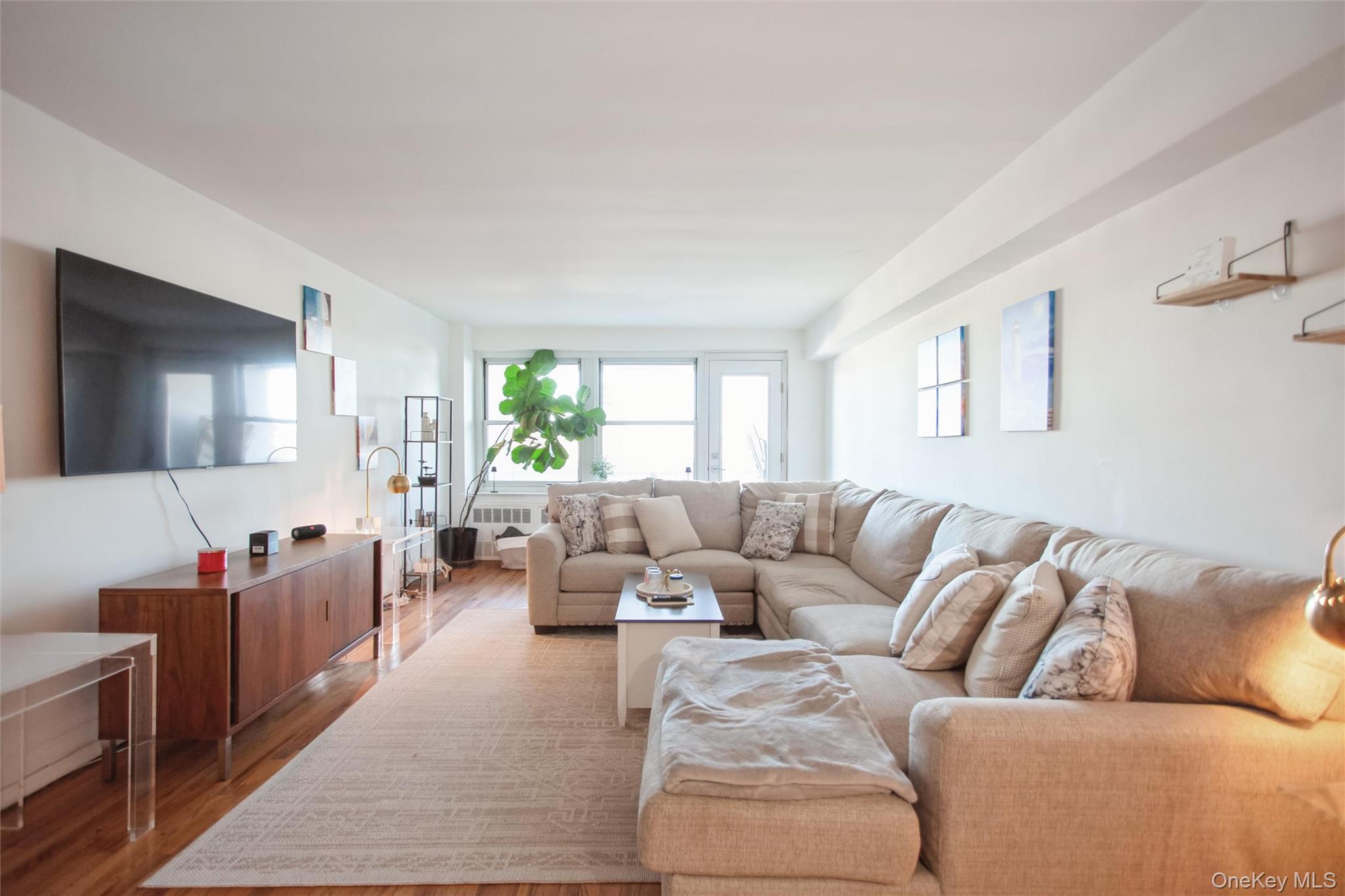 711 Shore Road, Unit 2C Long Beach, NY 11561 - Photo 6 of 27 a living room with furniture and a flat screen tv