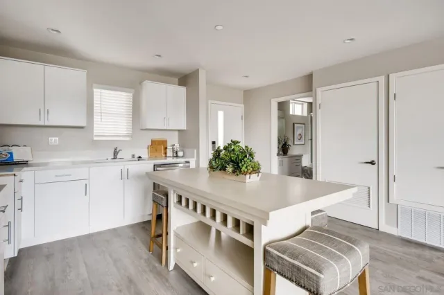 a kitchen that has a lot of cabinets in it and wooden floors